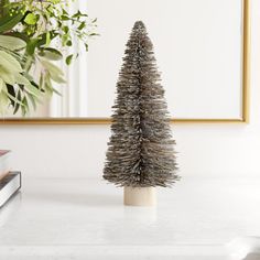 a small christmas tree sitting on top of a white table