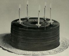 a black and white photo of a birthday cake with candles on the top, surrounded by frosting