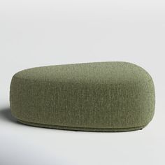 a green ottoman sitting on top of a white floor