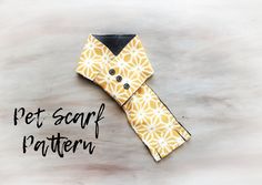 an origami dog collar made out of yellow and white fabric with the words pet scarf pattern on it