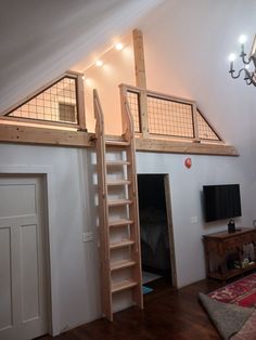 a loft bed with a ladder to the top and a tv on the bottom floor