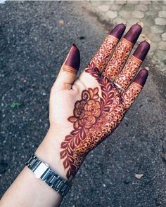 a woman's hand with henna tattoos on it