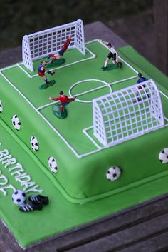 a green cake with soccer players on it