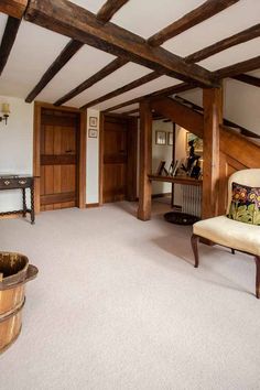 a living room filled with furniture and wooden beams