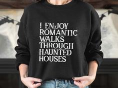 a woman wearing a black sweatshirt that says i enjoy romantic walks through haunted houses