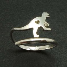 a silver ring with a small dinosaur on it's side and a heart in the middle