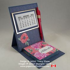 a desk calendar with a red pen in it and a card holder on the front