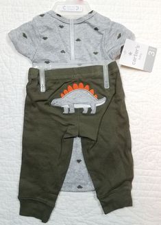 This is a New Baby Boy's Carters Turn Me Around Pants and Bodysuit 2 Piece Set. Bodysuit is gray with dark green dinosaur print, and on the back of the pants there is a dinosaur picture. Available in Size 3, 6, 9, and 12 Months. Please see Photos. Thanks for Looking!