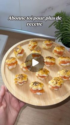 a person holding a wooden plate with small sandwiches on it and the words above them