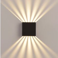 a black square light fixture on a white wall