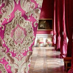 an ornately decorated room with red drapes and pink curtains on either side of the doorway