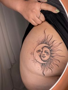 a pregnant woman's belly with the sun and moon tattoo on her side,