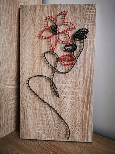 a wooden plaque with a drawing of a woman's face and flowers on it