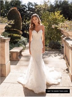 a woman in a wedding dress standing outside