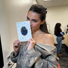 a woman holding up a card in an office