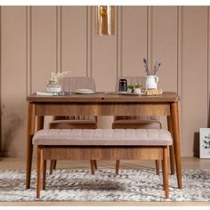 a wooden table with two benches on top of it and a rug in front of it