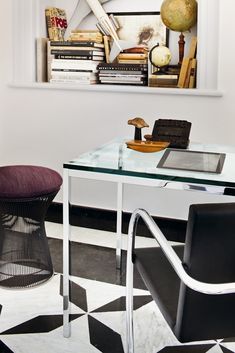 an office with a desk, chair and bookshelf on the wall above it