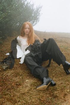 a woman sitting on the ground next to a dog