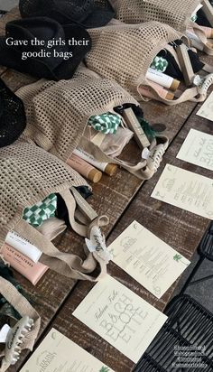 several bags with tags on them sitting on top of a wooden table covered in burlocks