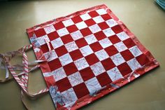 a red and white checkered piece of cloth on a table with ribbon around it