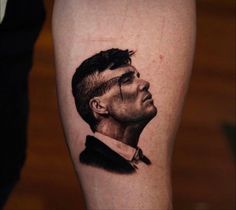 a man's arm with a portrait of himself on the left side of his leg