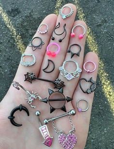 a person holding many different types of rings in their hand, all with charms attached to them