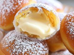 some powdered sugar covered donuts with icing on them sitting in a pile