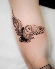 an owl tattoo on the left arm