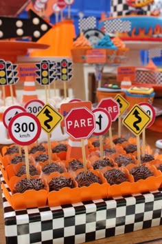 a table topped with lots of cupcakes covered in frosting and candies