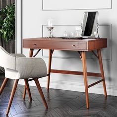 a wooden desk with a laptop on top of it next to a chair and potted plant