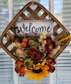 a welcome sign hanging from the side of a window with sunflowers and leaves