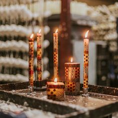 several candles are lit on a tray in the middle of a room filled with other items