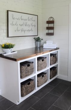 a white shelf with baskets on top and a sign above it