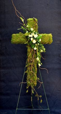 a cross made out of moss and flowers