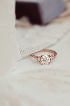 a diamond ring sitting on top of a white cloth