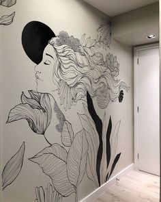 a woman with long hair and flowers painted on the side of a wall in an office