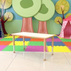 a child's playroom with colorful carpet, trees and tent in the background