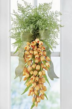 This whimsical door swag is shaped like a giant carrot that's crafted from faux orange tulips and topped off with sprigs of carrot-like greenery.