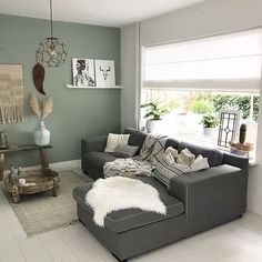 a living room with gray couches and white rugs on the hardwood flooring