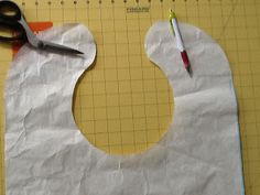 a pair of scissors is sitting on top of a piece of paper with a hole in it