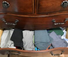 an open drawer with clothes in it