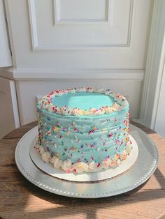 a cake with frosting and sprinkles sitting on top of a table