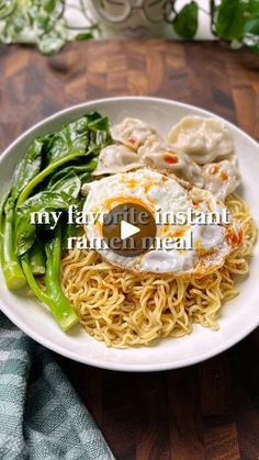 a white plate topped with noodles and veggies on top of a wooden table