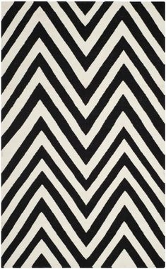 a black and white rug with large chevrons on the bottom, in an irregular pattern