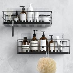 two metal shelves with soap, lotion and other bathroom items hanging on the wall