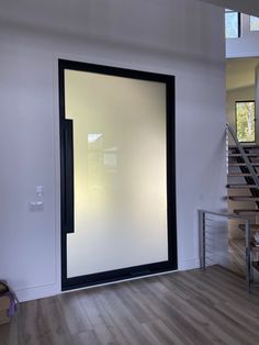 an empty room with a glass door and stairs leading up to the second floor area