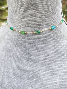 Super dainty emerald green crystal beaded choker made from gold plated stainless steel and beautiful little long green crystals. PLEASE read my shop announcement before placing an order so you know what to expect right now. Plus, when ordering from outside Europe, don't forget to provide a phone number for the courier to ensure the fastest and smoothest delivery Stainless steel chain and findings, won't rust or anything  Fastens with a solid lobster clasp, and has an extension chain.   Choker is Dainty Emerald Jewelry With Adjustable Chain, Bohemian Gold Jewelry With Emeralds, Green Jewelry With Adjustable Chain And Round Beads, Green Beaded Chain Jewelry, Green Jewelry With Round Beads And Adjustable Chain, Adjustable Necklace With May Birthstone, Dainty Green Jewelry With Delicate Chain, Dainty Green Emerald Jewelry, Green Choker Jewelry With Adjustable Chain