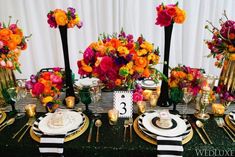 the table is set with black, white and gold place settings