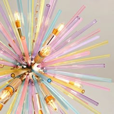 a multicolored chandelier with many lights on it's sides and one light bulb in the middle