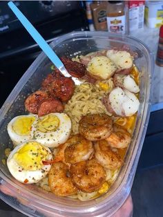 a plastic container filled with pasta and shrimp